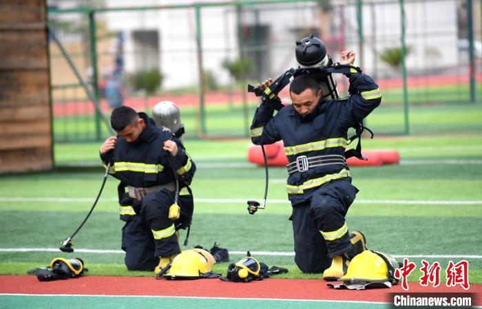 新消防員進(jìn)行穿戴空呼器展示?！⒅铱?攝