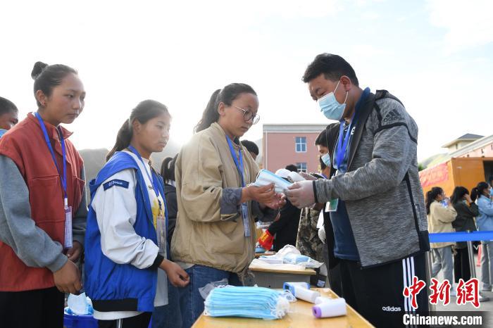 7月7日，考生在拉薩三高考點(diǎn)外領(lǐng)取口罩?！『闻罾?攝
