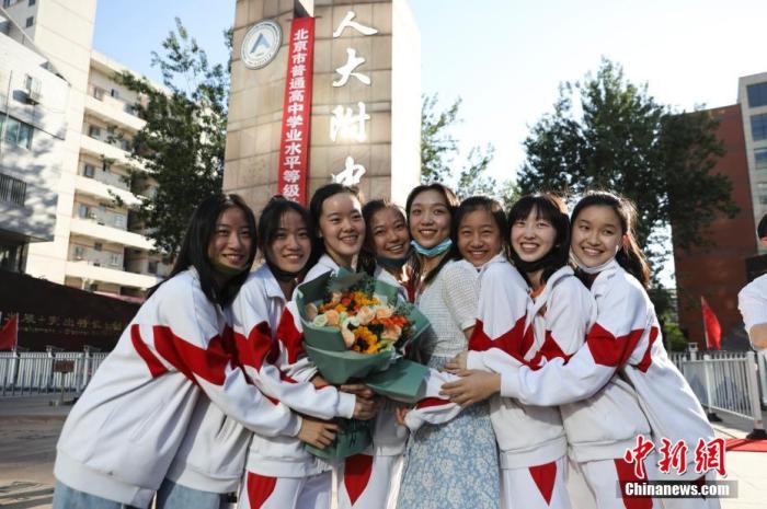 資料圖：6月10日，在北京人大附中高考考點(diǎn)外，考生們相擁拍照留念。當(dāng)日，北京市2021年高考結(jié)束?！?<a target='_blank'  data-cke-saved- ><p  align=